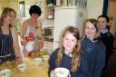 Esther Yates (left) and Rachel Bloxham prepare food while pupils Megan Cave, Millie Styles and Harriet Hope (pictured left to right) queue for fruit salad.