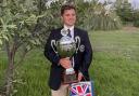 Luke Russell with his trophy and medal after winning the World Compak Clay Shooting Championships in Pschana, Greece