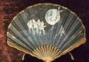 A painted fan by Van Garden dating from circa 1900 showing Pierrots pulling a tooth from the mouth of the Man in the Moon