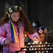 Girl lights candles following Russian invasion of Ukraine. Photo: PA.