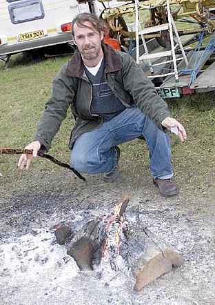 Dean Burton warming himself by the fire at Stow Horse Fair.